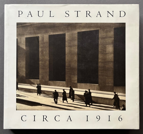 Book titled 'Paul Strand: Circa 1916' with a white cover featuring the image of people walking along Wall Street in Manhattan, New York.