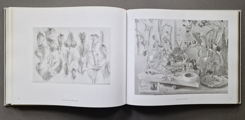 An open book spread showing two monochrome botanical and still-life photos on white pages.