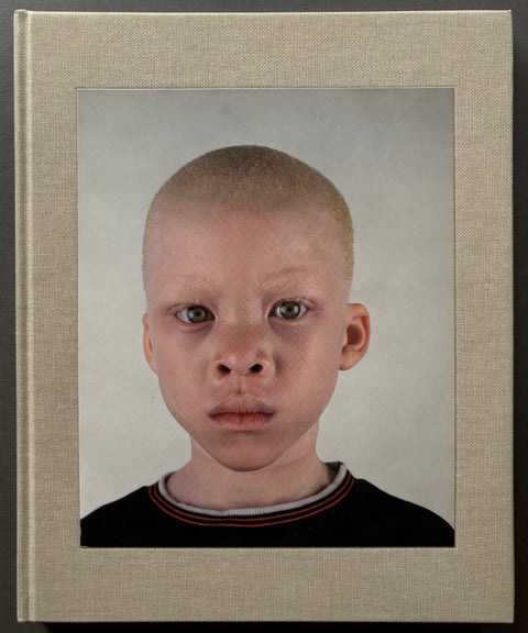 Book titled 'Looking Aside' by Pieter Hugo with a beige cover featuring the portrait of a boy with albinism.