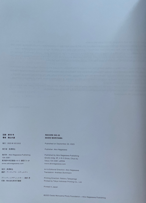 A white paper document or booklet page with printed Japanese text and small publication details, photographed against a light gray background with a soft shadow.