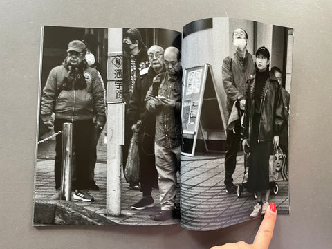 Open book showing black and white photos of people on a street corner.