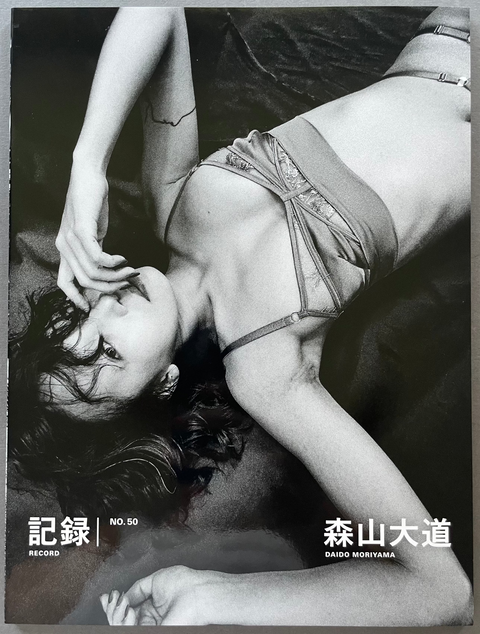 Front cover of Record No.50 by Daido Moriyama with a black and white portrait of a woman. 