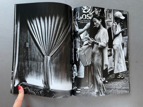 Open book displaying black and white photographs of people and a curtain.