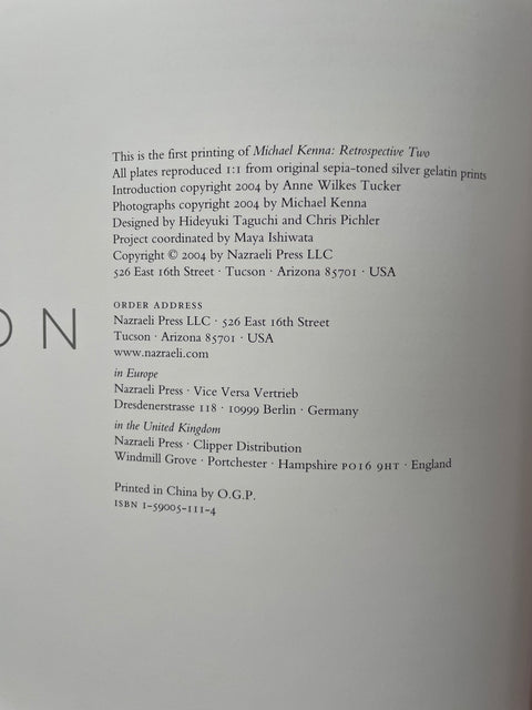 A close-up of a printed book or album cover page showing publication details and copyright information for Michael Kenna's 'Retrospective Two' on Nazraeli Press.