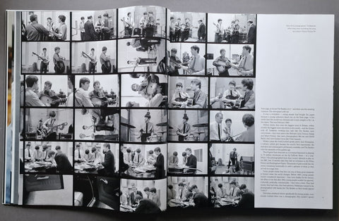 An open book spread showing a large black-and-white photo grid on the left page and a column of text on the right page, photographed against a dark surface.