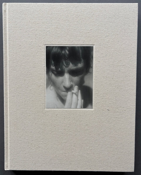 Book titled 'Gumsucker' with a beige cover featuring the tipped in, close up head shot, of a woman smoking a cigarette