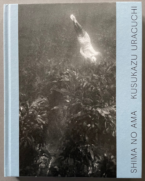Front cover of Shima No Ama by Kusukazu Uraguchi with a black and white image of a diver on blue background. 