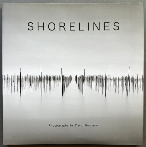 Cover of the book 'Shorelines' by David Burdeny, featuring a black and white photograph of a shoreline with text and a signature on the title page.