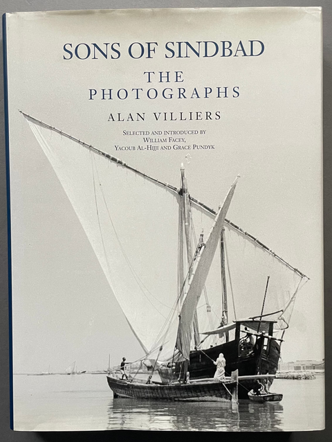 The book 'Sons of Sindbad: The Photographs' by Alan Villiers, featuring a black and white cover illustration of a traditional sailing boat, photographed against a neutral gray background.