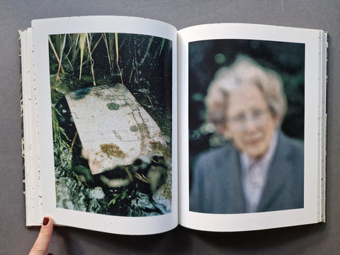 An open book, showing two printed photographs on the spread: one of a turtle in reeds, and one of a blurred portrait of an older woman. 