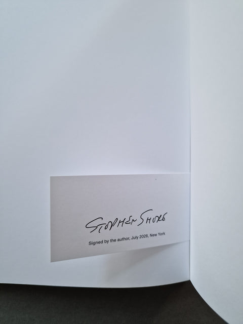 A close-up of the inside cover of a book, showing a white page with a printed signature reading Stephen Shore and smaller text below