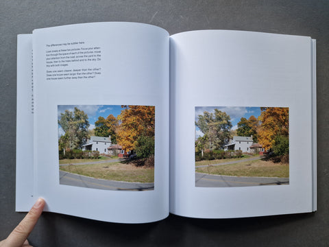 An open book showing printed text and two landscape photographs of houses surrounded by autumn trees