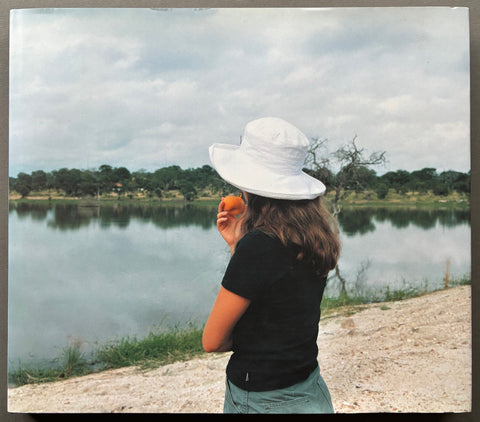 Book titled 'How Beautiful This Place Can Be' by Stuart O'Sullivan with a cover featuring the image of a woman looking out of a body of water eating a peach.