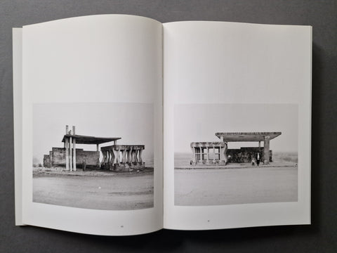 An open book spread showing two black-and-white architectural photographs printed on the pages.