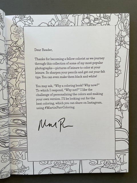 An open coloring book showing a printed letter signed by Martin Parr, with black-and-white illustrated border pages on both sides.