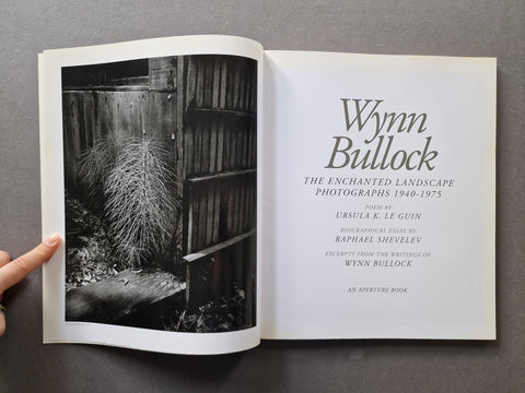 An open book titled 'Wynn Bullock: The Enchanted Landscape Photographs 1940-1975' 