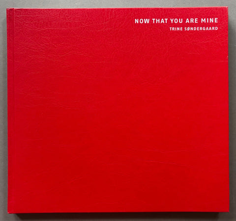 Book titled 'Now That You Are Mine' by Trine Sondergaard with a red cover.