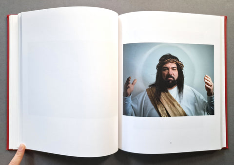 An open book spread with a blank left page and a portrait of a person dressed as Jesus Christ on the right page.