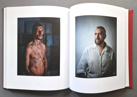 An open hardcover book showing two printed portrait photographs on the left and right pages.