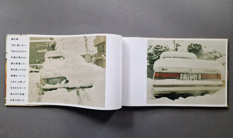 An open book, showing two printed pages with photographs of snow-covered cars and Japanese text along the left margin.