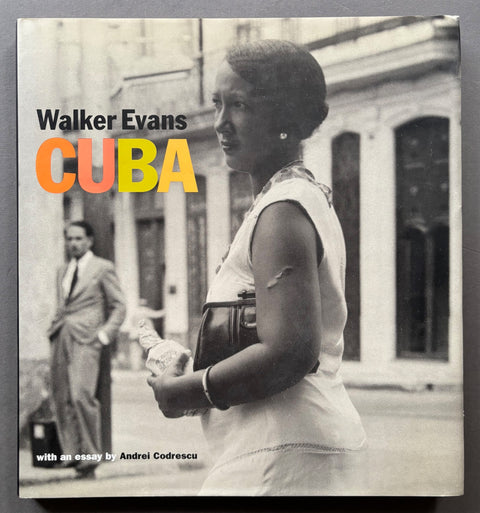 Book titled 'Cuba' by Walker Evans with a cover featuring ablack and white image of a woman in the foreground and an man in the back ground.