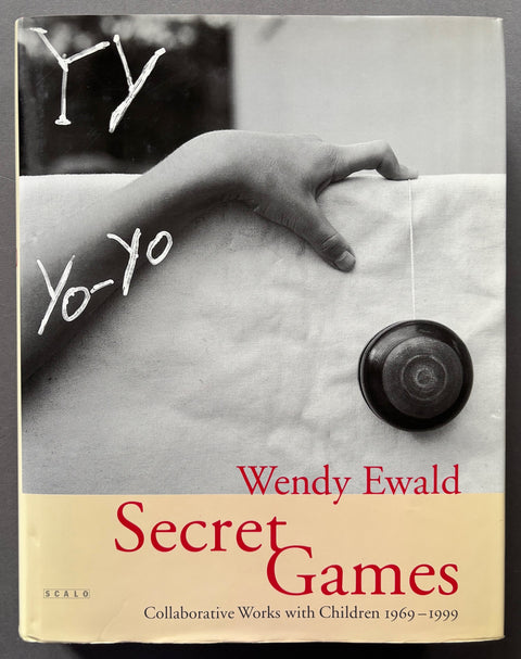 Book titled 'Secret Games: Collaborative Works with Children 1969-1999' by Wendy Ewald with a beige cover featuring the image of a child's hand and a yo-yo.