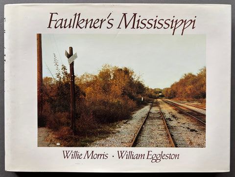 Book titled 'Faulkner's Mississippi' by Willie Morris and William Eggleston with a white cover featuring an image of a train track.