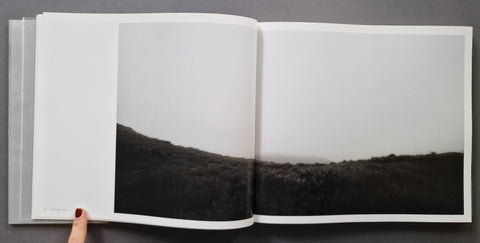 an open book spread showing a landscape photograph of a field and the horizon