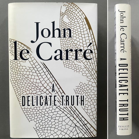 This image features the cover of "A Delicate Truth," a 2013 spy novel by John le Carére. The book's cover is elegantly designed with a detailed, textured pattern that gives a sense of the novel's intricate and lies-within-lies narrative.