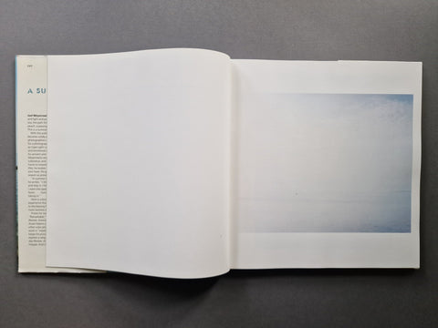 An open book, showing a seascape on the right.