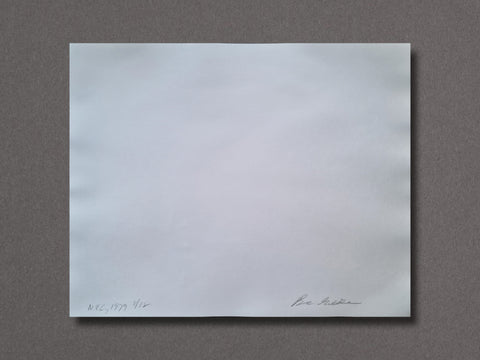 A back of an art print, featuring small handwritten text in the bottom-left corner and a signature in the bottom-right, displayed against a dark gray background.