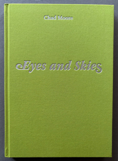 Book titled 'Eyes and Skies' by Chad Moore with a green cover and silver type.