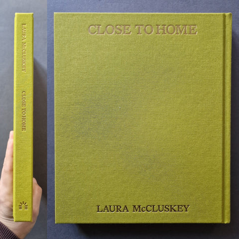 A hardcover book titled "Close to Home" by Laura McCluskey, shown from the front and spine. The cover is a textured olive green with the title embossed at the top and the author's name at the bottom.