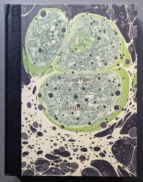 A hardcover book titled 'Coexistence' by Stephen Gill, featuring a marbled cover design with green, beige, and black organic patterns.