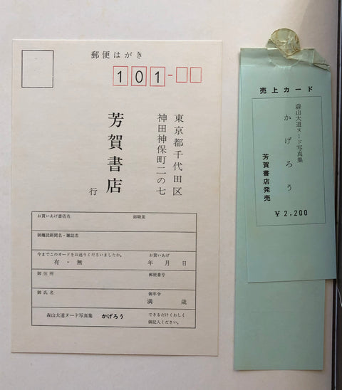 A vintage Japanese postcard and an accompanying paper voucher or receipt, photographed against a plain off-white background. The postcard is off-white with black printed Japanese text and a red numbered stamp area.