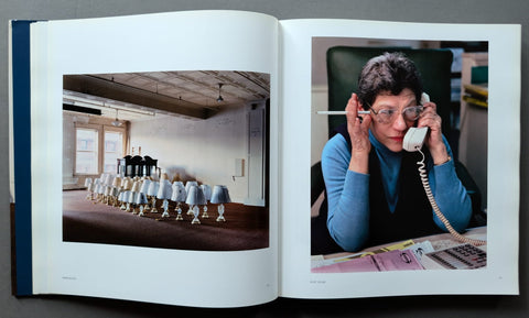 An open art book, showing two printed photographs. The left page contains a photograph of many small white lamps arranged in a room.