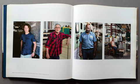 An open book showing four printed portrait photographs on white pages, photographed from above against a dark gray background.