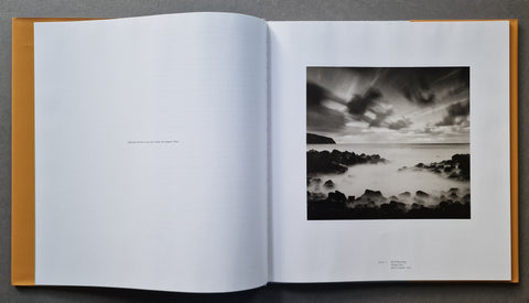 An open hardcover book, showing a black-and-white landscape photograph printed on the right page.