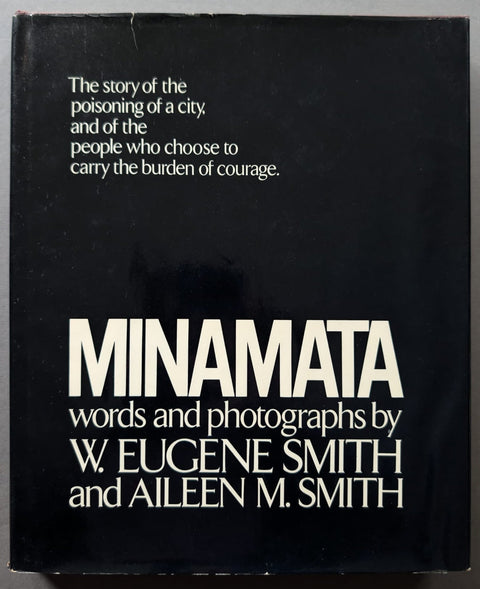 A black book cover with white text reading 'MINAMATA words and photographs by W. Eugene Smith and Aileen M.