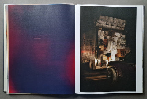An open art book. The left page has an abstract gradient design blending dark blue, purple, and red.