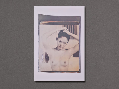 A square photographic art print featuring a vintage-style sepia-toned portrait of a nude woman with her hands in her hair.