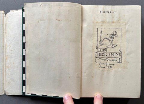 Open book with a 'This Book is Mine' stamp on a gray background