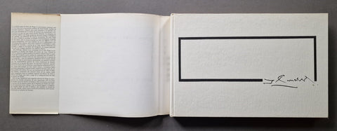 An open book or art print with blank white pages, featuring a black rectangular border on the right page 
