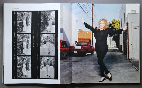An open art book spread, showing a black-and-white photo collage on the left page and a color photograph of a woman  (Bette Midler) in a black outfit standing in an alley on the right page.