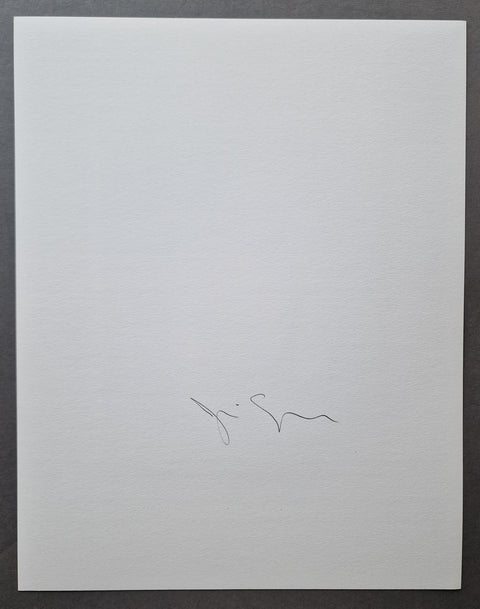 A square white textured paper print with a small black handwritten signature near the bottom center, photographed against a dark gray background.