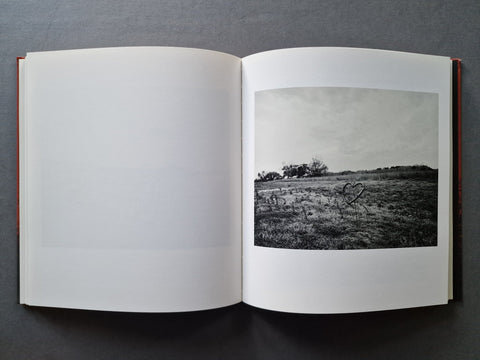 An open book, showing a black-and-white landscape photograph printed on the right page.
