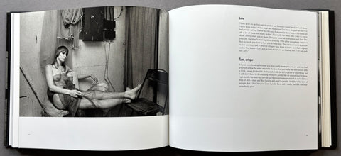 An open book showing a black-and-white interior photograph on the left page and printed text on the right page, photographed from above against a dark background.