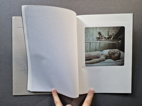An open book psread with the left page black and a photo of an alien on the right