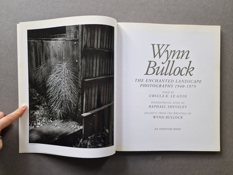 An open book titled 'Wynn Bullock: The Enchanted Landscape Photographs 1940-1975' 
