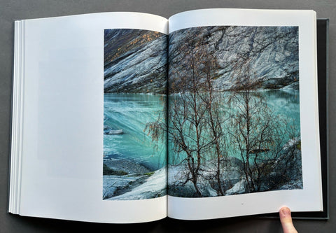 Open book showing a scenic photograph of a lake and trees.